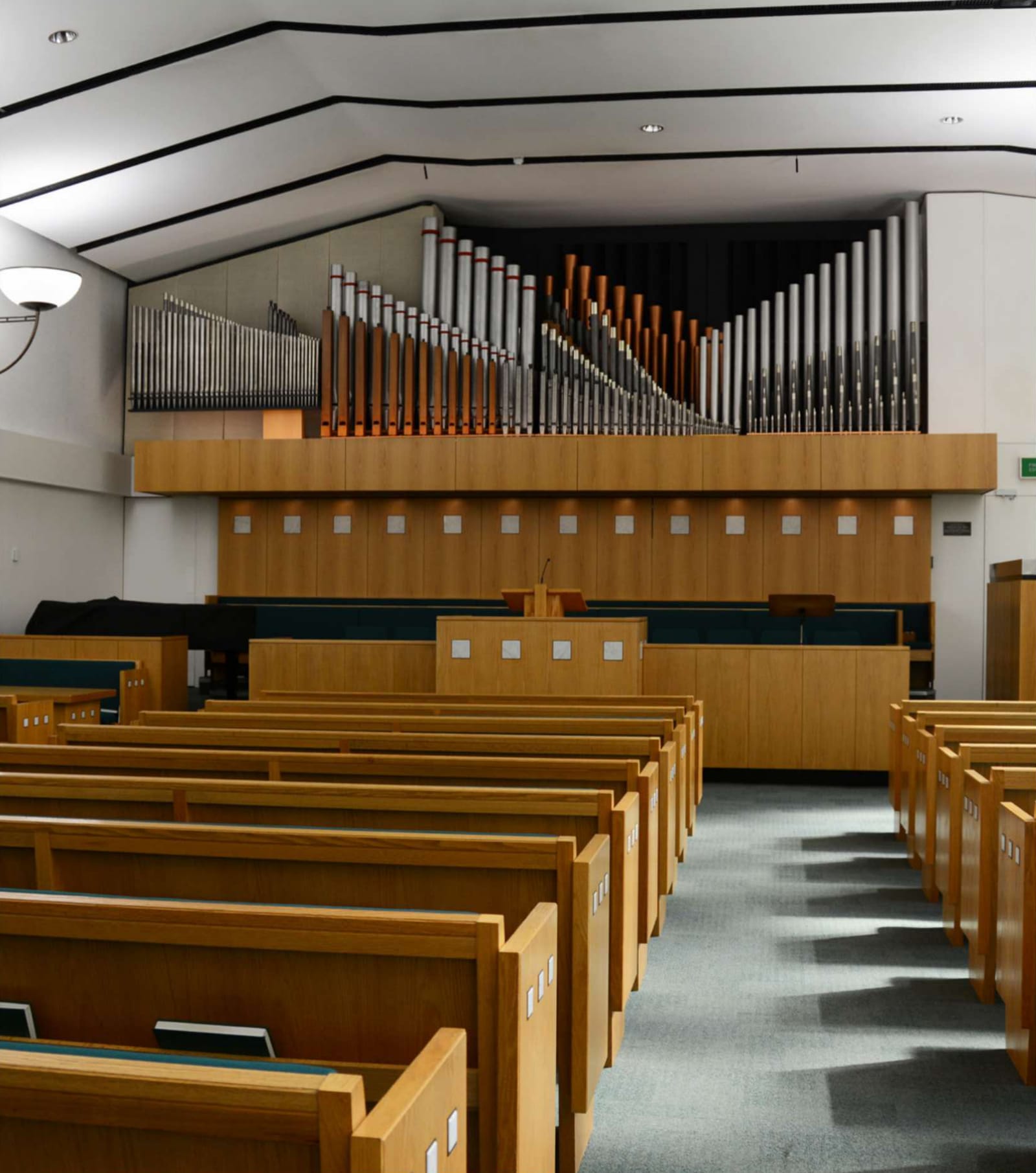 Meetinghouse chapel: rows of wooden pews facing a rostrum, with organ pipes above